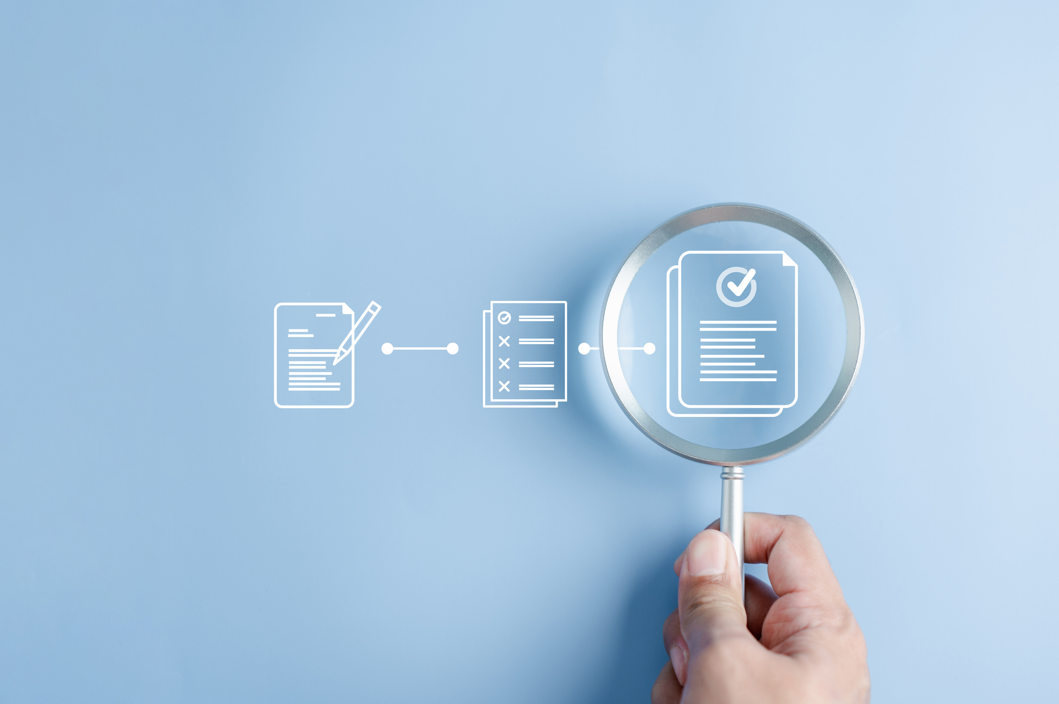 A hand holds a magnifying glass over an illustration of a document