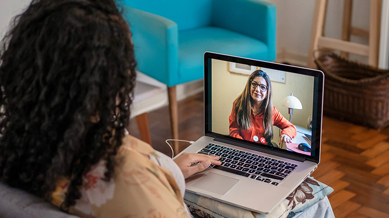 Woman sitting in front of laptop meeting call